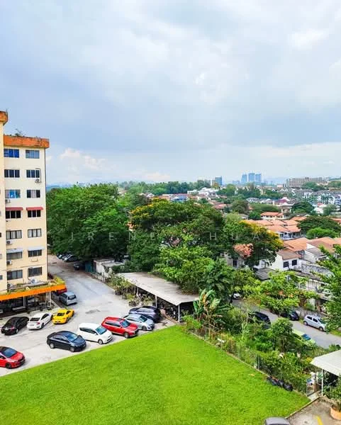Exterior type: low-rise apartment block; features: green lawn, parking lot with multiple cars, surrounding trees, city skyline in background, residential buildings in vicinity, cloudy sky; style: modern.