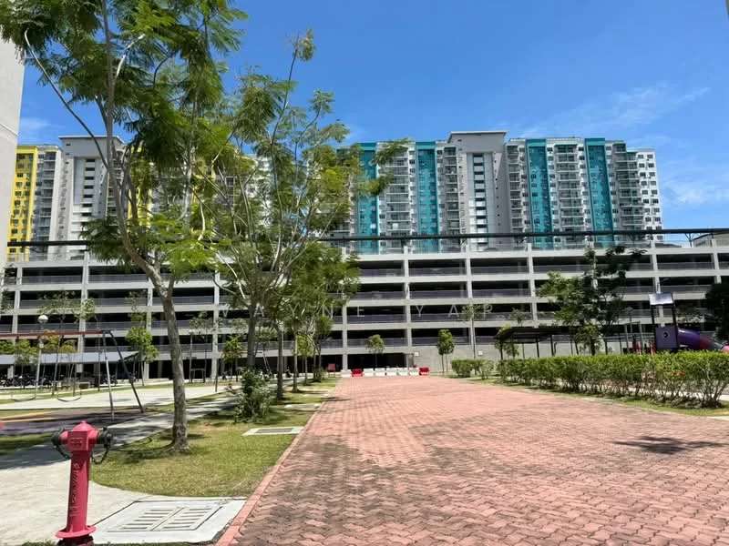 Exterior type: high-rise condominium; features: multi-storey car park, manicured lawn, mature trees, paved walkway, playground area, surrounding greenery, residential building with balconies, open space, blue sky; style: modern.