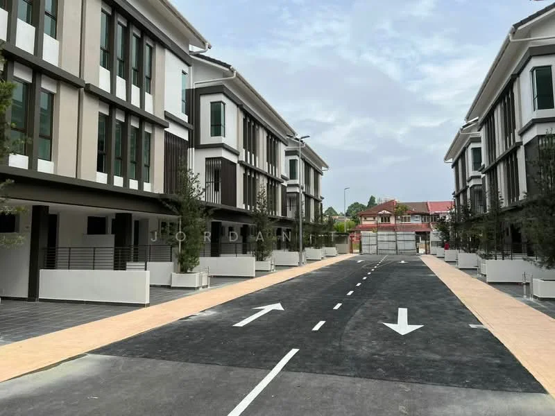 Exterior type: linked terrace house; features: modern facade with horizontal and vertical elements, two-storey buildings, white painted facade, grey accent panels, manicured landscaping with small trees, paved driveway, marked parking spaces, surrounding residential area, gated entrance with security, clear sky, urban context; style: modern.