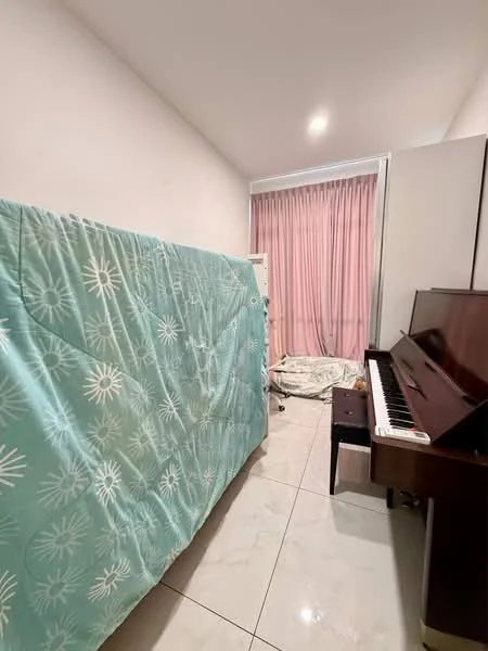 Room features: white painted walls, tile flooring, large window with sheer curtains, piano, bed covered with a quilt, small stool, bed linens on the floor, built-in wardrobe.