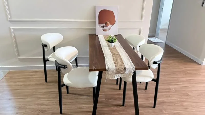 Dining features: wood dining table, 6-seater dining table, white upholstered dining chairs, black metal chair legs, decorative table runner, small potted plant on table, framed artwork on wall, light-colored walls, laminate flooring; style: modern.