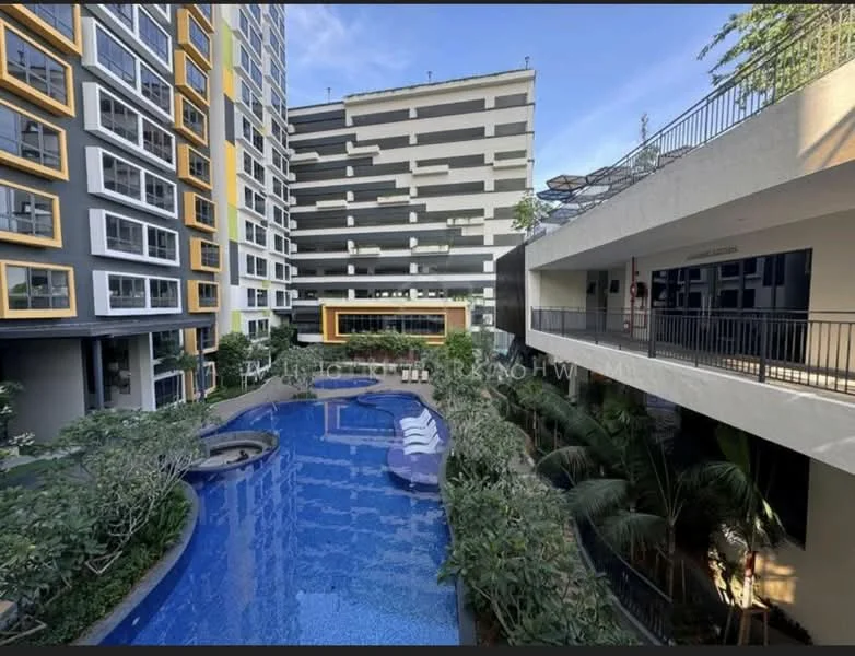 Exterior type: high-rise condominium; features: infinity pool, pool deck with loungers, landscaped garden with tropical plants, multiple-storey building, balconies with glass railings, modern facade with yellow and grey accents, outdoor seating area, surrounding greenery; style: modern.