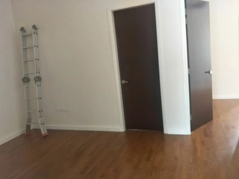 Room features: laminate flooring, white painted walls, brown wooden door, ladder, doorway, corner layout.