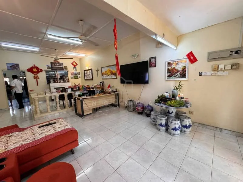 Living features: red fabric sofa, coffee table, wall-mounted TV, decorative wall art, white tiled flooring, ceiling fan, dining table with chairs, decorative plants, ceramic jars, wall-mounted electrical panel, cross decoration, Chinese New Year decorations; style: traditional. Kitchen features: open kitchen layout, white cabinetry, kitchen counter, stainless-steel appliances, wall-mounted shelves; style: traditional.