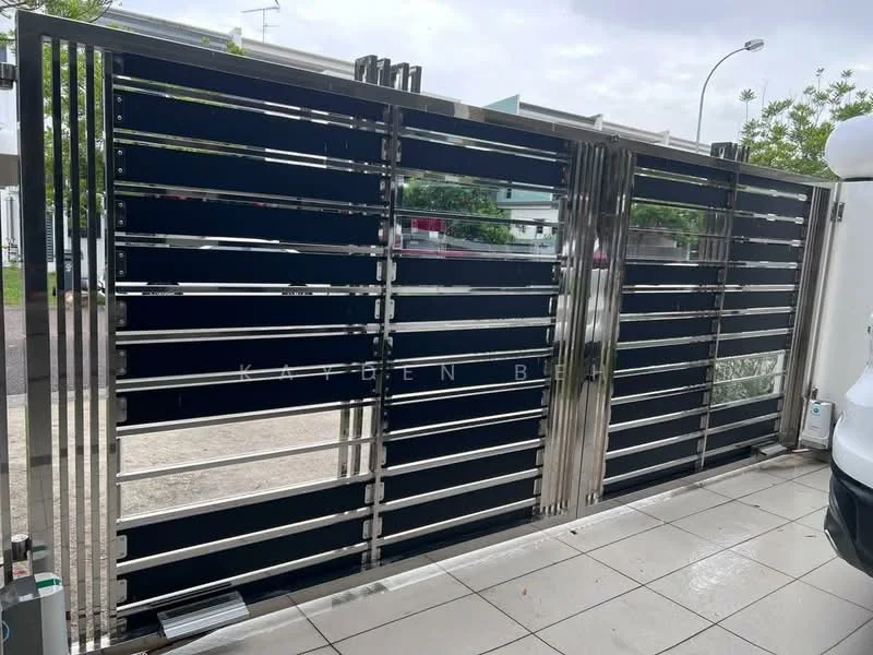 Exterior features: metal gate with horizontal slats, stainless steel frame, black painted slats, paved flooring, surrounding greenery, urban setting; style: modern.
