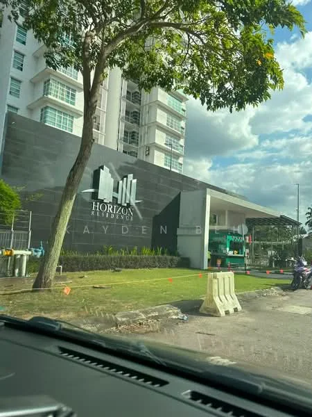 Exterior type: high-rise condominium; features: glass curtain wall, white painted facade, landscaped garden, manicured lawn, entrance with awning, signage with building name, surrounded by greenery, parking area visible; style: modern.