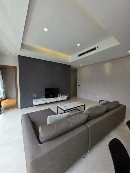 Living features: L-shape sectional sofa in grey, coffee table with black frame, wall-mounted TV, white TV console, recessed downlights, tray ceiling, grey accent wall, cream painted walls, marble flooring; style: modern.