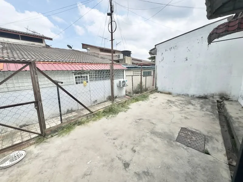 Exterior features: concrete flooring, fenced perimeter, exposed brick wall, air conditioning unit, roof overhang, surrounding residential buildings, power lines visible, open space.