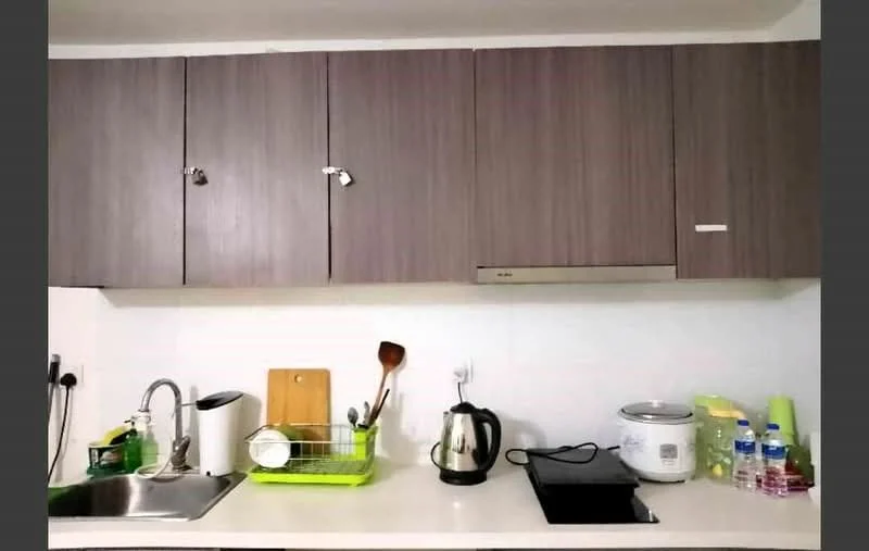 Kitchen features: wooden cabinetry in dark brown, white countertop, single-bowl stainless-steel sink, chrome pull-down faucet, built-in stove, electric kettle in silver, rice cooker in white, cutting board in wood, dish drying rack in green, bottled water, small kitchen appliances, wall-mounted cabinets; style: modern.