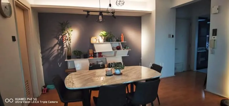 Dining features: 6-seater dining table with marble top, black upholstered dining chairs, shelf with decorative plants and books, grey accent wall, wooden flooring, hanging pendant lights, wall-mounted shelf, decorative items on shelf; style: modern. Room features: open layout to adjacent room, light-colored walls, doorway leading to kitchen.