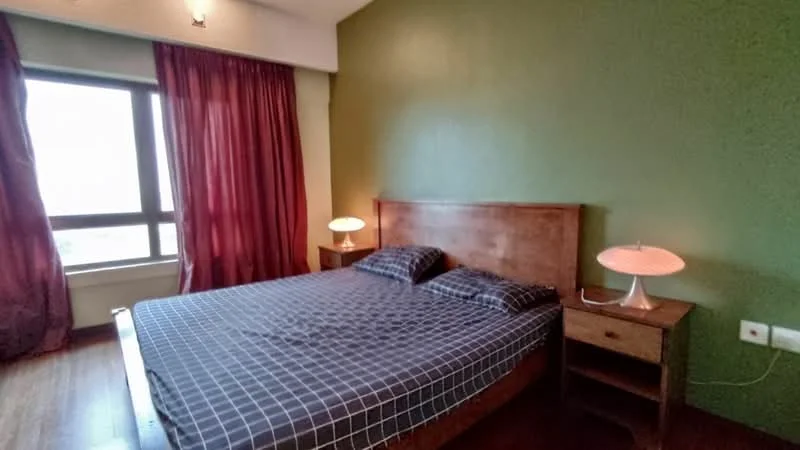 Bedroom features: green painted walls, wooden flooring, king-size bed, plaid bedding, two bedside tables, table lamps with white shades, floor-to-ceiling window, red curtains; style: modern.