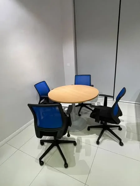 Room features: round wooden table, four black office chairs with blue mesh backs, white tiled flooring, grey painted walls, large window with roller blinds; style: modern.