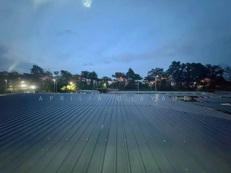 Exterior features: metal roofing, nighttime lighting, surrounding trees, urban landscape, cloudy sky; style: modern.