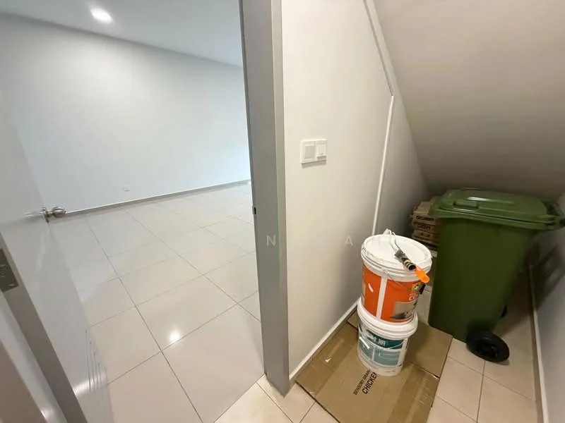 Room features: white painted walls, glossy ceramic tile flooring, corner with sloped ceiling, green waste bin, stack of cardboard boxes, paint buckets.
