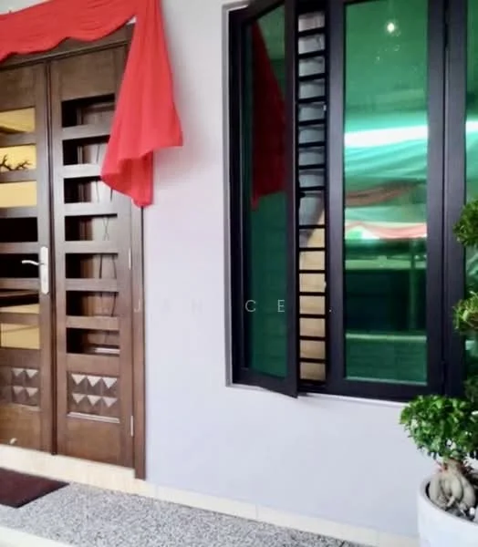 Exterior features: wooden front door with decorative panels, black framed window with louvered design, grey exterior wall, stone-paved walkway, red fabric draped above the door, small potted plant; style: modern.