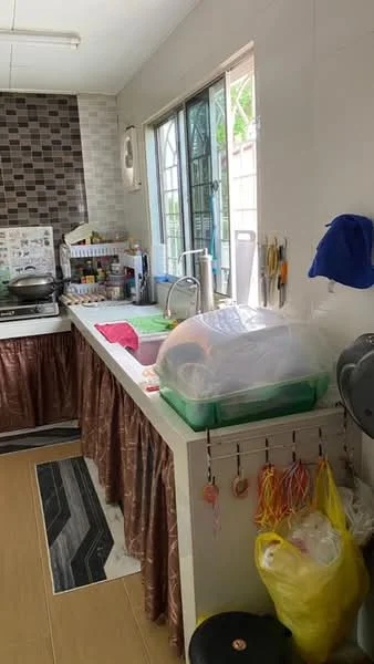 Kitchen features: double-bowl stainless-steel sink, chrome pull-down faucet, green countertop, grey patterned backsplash, white cabinetry, kitchen island with storage, black and white area rug, window with metal grille, wall-mounted kitchen utensils, various kitchen appliances visible, plastic storage containers, hanging storage bags; style: modern.