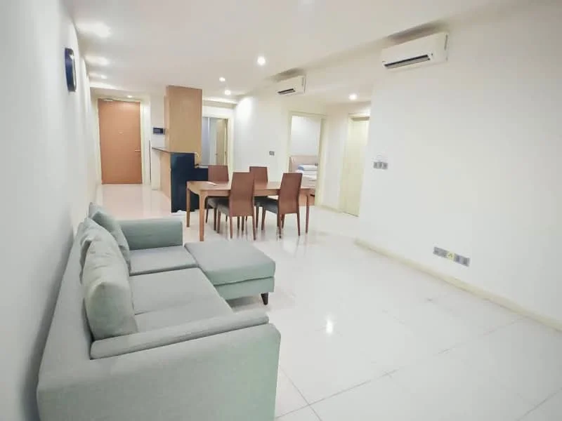 Living features: light grey fabric sofa, 4-seater dining table, brown wooden dining chairs, white walls, white tiled flooring, recessed downlights, 2 wall-mounted split AC units, open layout, doorway leading to other rooms; style: modern.