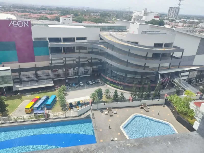 Exterior type: shopping mall; features: multi-storey building, glass facade, outdoor swimming pool, landscaped garden area, parking area with buses, manicured lawn, surrounding urban context, signage for AEON, pool deck with loungers; style: modern.