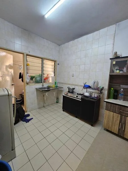 Kitchen features: white tiled walls, light grey tiled flooring, single-bowl stainless-steel sink, chrome faucet, freestanding gas stove, wooden kitchen cabinet, countertop with space for appliances, window with horizontal slats, refrigerator, kitchen utensils on countertop, plastic containers, cleaning supplies, door leading to hallway; style: functional.