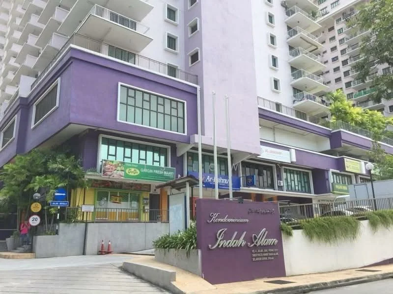 Exterior type: mid-rise condominium; features: purple painted facade, glass windows, ground floor retail spaces, signage for shops, landscaped greenery, entrance with gate, parking area, multiple storeys, balconies on upper floors; style: modern.