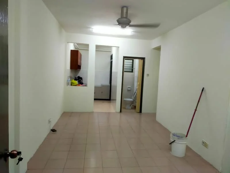 Room features: white painted walls, tile flooring, ceiling fan, doorway leading to another room, open kitchen area with cabinets, visible bathroom door, cleaning supplies visible, bucket on the floor.