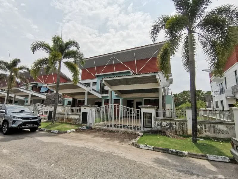 Exterior type: linked terrace house; features: red painted facade, flat roof, manicured lawn, palm trees, fenced front yard, driveway with interlocking pavers, two-storey structure, covered porch, visible car parking, multiple windows, balconies on upper level; style: modern.