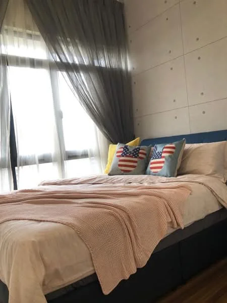 Bedroom features: king-size bed, upholstered headboard, bedding in neutral tones, decorative throw blanket in light pink, two decorative pillows with American flag design, floor-to-ceiling windows, sheer curtains, grey accent wall with textured finish, wooden flooring; style: modern.