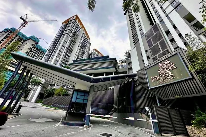 Exterior type: high-rise condominium; features: modern facade with glass and concrete, double-volume main lobby, guard house at entrance, gated entry, landscaped surroundings with trees, driveway with interlocking pavers, visible construction crane in background, signage with property name, multiple storeys visible; style: modern.