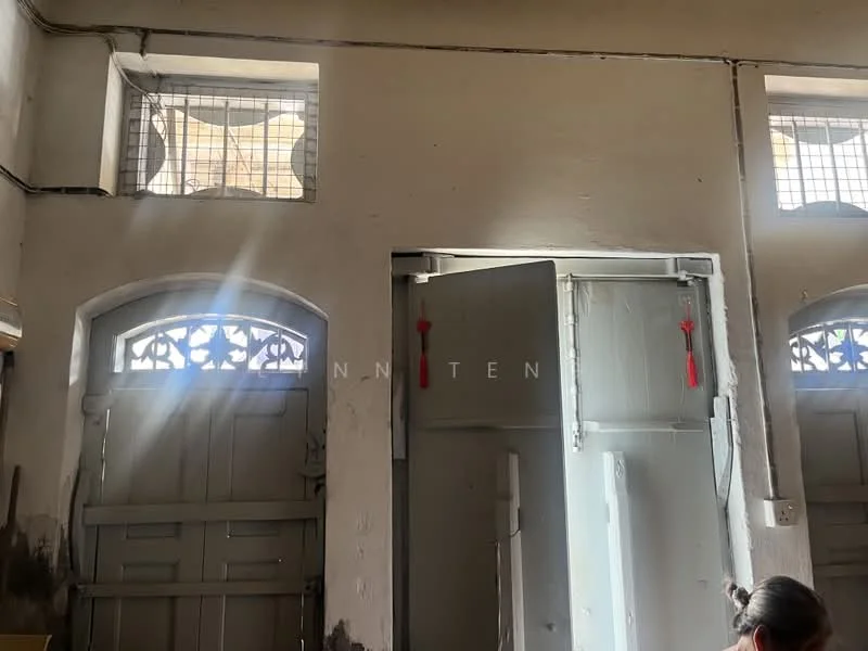 Room features: white painted walls, wooden doors, arched windows with metal grilles, natural light from windows, exposed ceiling beams, light streaming through windows, decorative door handles, flooring not visible; style: traditional.