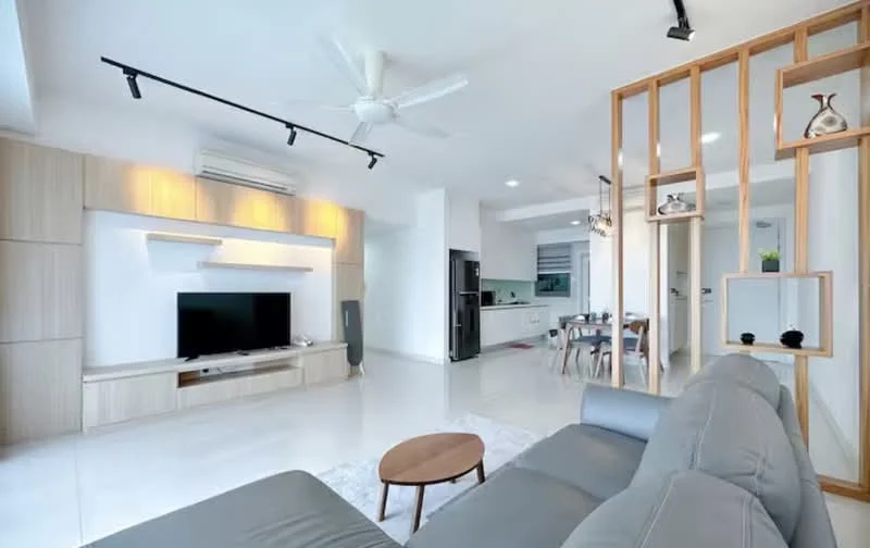 Living features: grey fabric sofa, coffee table, wall-mounted TV, TV console with storage, recessed lighting, 5-blade ceiling fan with light, white painted walls, glossy tile flooring, open-plan layout to dining area, decorative wooden partition, air conditioning unit; style: modern. Dining features: dining table for four, upholstered dining chairs, open layout to living area; style: modern. Kitchen features: kitchen island, stainless-steel fridge, built-in oven, cabinets with wood finish, countertop with backsplash, open layout to dining area; style: modern.
