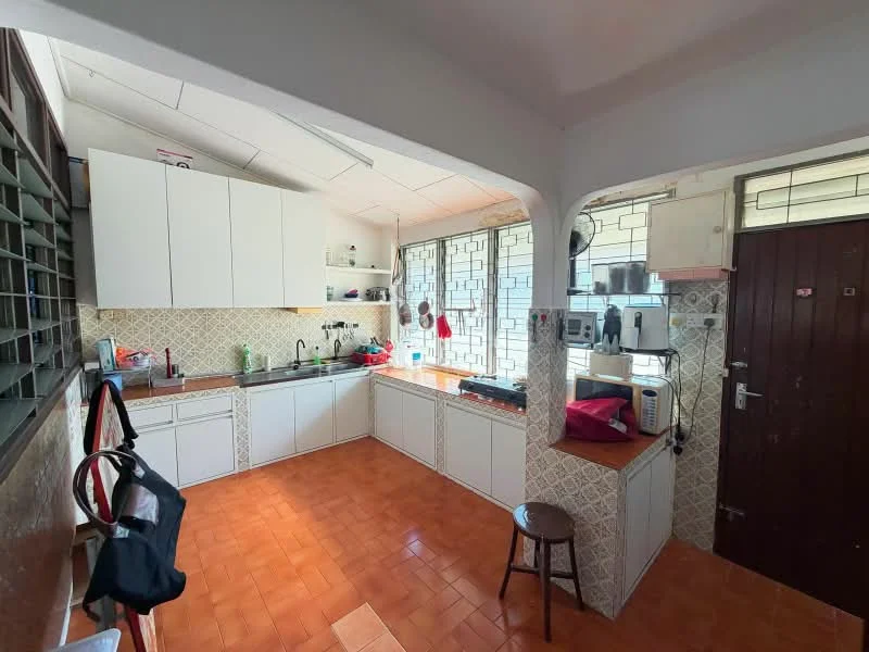 Kitchen features: white cabinetry, ceramic tile backsplash, stainless-steel sink, chrome pull-down faucet, built-in oven, freestanding range oven, microwave, kettle, toaster, tile flooring in orange, window with sheer curtains, countertop with space for appliances, stool, door leading to exterior.