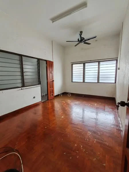 Room features: wooden flooring, white painted walls, ceiling fan, two windows with horizontal slats, single wooden door, light fixture on ceiling.