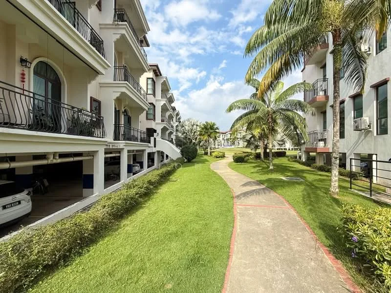 Exterior type: low-rise apartment block; features: manicured lawn, paved walkway, palm trees, balconies on upper floors, air conditioning units visible, surrounded by greenery, two-storey buildings, decorative railings; style: modern.
