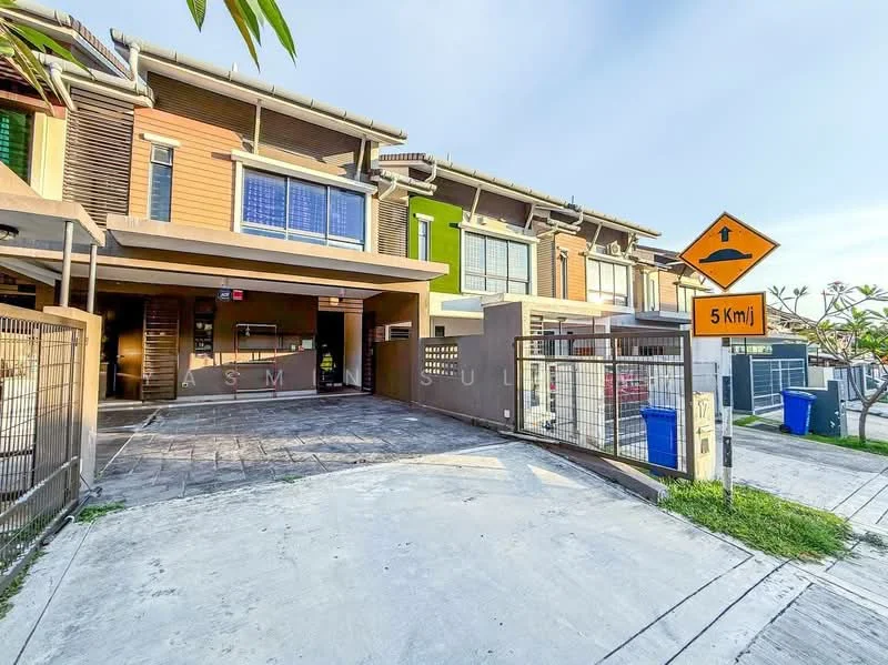 Exterior type: linked terrace house; features: two-storey building, brown painted facade, green accent doors, sliding glass door, manicured landscaping, paved driveway, security gate, visible parking area, street sign indicating speed limit, fenced perimeter; style: modern.