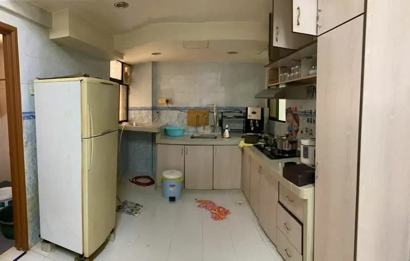 Kitchen features: white cabinetry, light-colored countertops, stainless-steel sink, chrome faucet, built-in stove, freestanding refrigerator, microwave, tile backsplash, white tiled flooring, window above sink, open shelving, kitchen utensils visible.