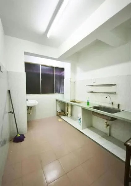 Kitchen features: white tiled walls, grey tiled flooring, single-bowl stainless-steel sink, chrome faucet, countertop with under-sink storage, window with black frame, wall-mounted shelves, floor-mounted plumbing, cleaning supplies visible, mop on the floor.