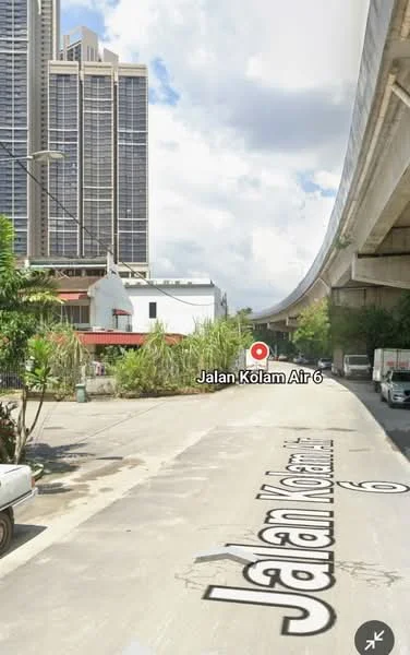 Exterior type: high-rise condominium; features: tall residential building, glass curtain wall, surrounding greenery, road with street name, overhead bridge, urban context; style: modern.