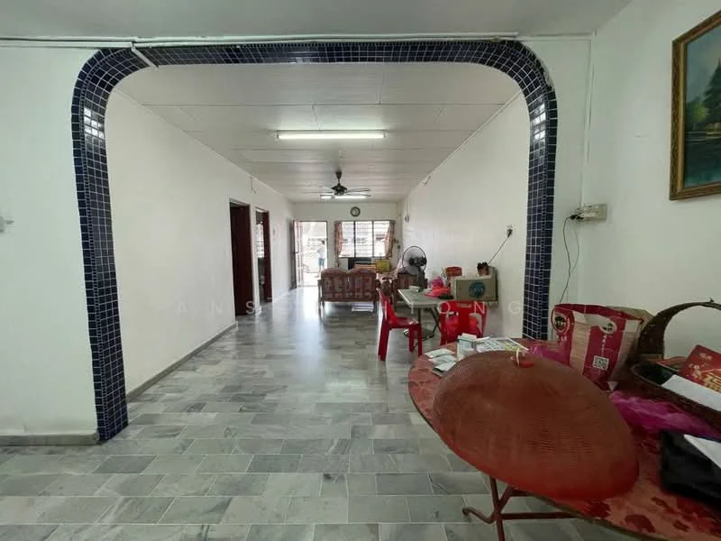 Room features: white painted walls, grey marble tile flooring, ceiling fan, arched entryway with blue tiles, windows with natural light, decorative painting on wall, red plastic chairs, round rattan table, fan, open layout; style: modern.