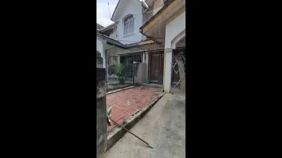 Exterior type: semi-detached house; features: brick pathway, fenced yard, garden area, white painted facade, gabled roof, window with grill, entrance door, outdoor lighting; style: traditional.