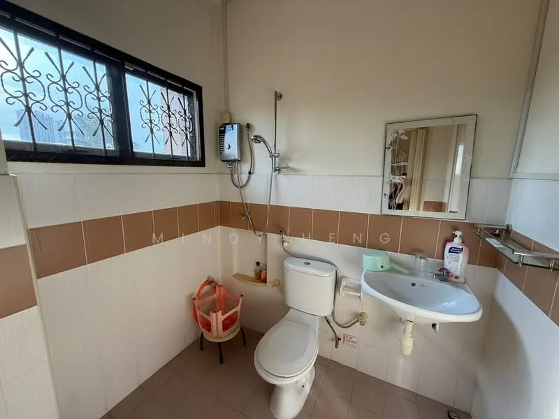 Bathroom features: white tiled walls, brown accent tiles, mirror above sink, chrome basin mixer faucet, white sink, one-piece toilet, shower with handheld showerhead, wall-mounted shower unit, window with security grille, tile flooring.