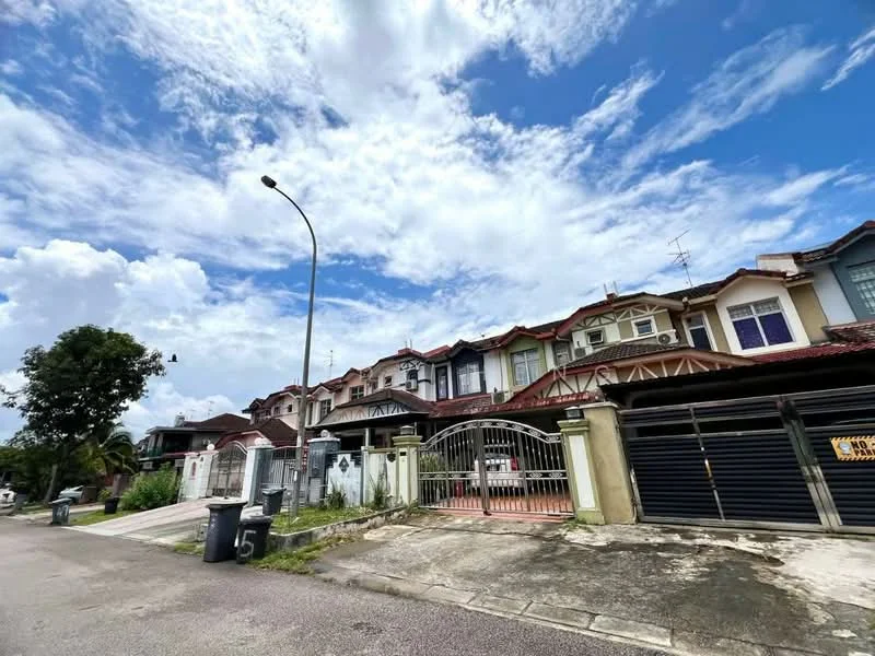 Exterior type: linked terrace house; features: two-storey linked terrace, red tiled roof, cream painted facade, decorative wooden eaves, front gate with iron bars, driveway with concrete pavement, visible garbage bins, street lamp, manicured front yard, surrounded by greenery, cloudy sky; style: modern.