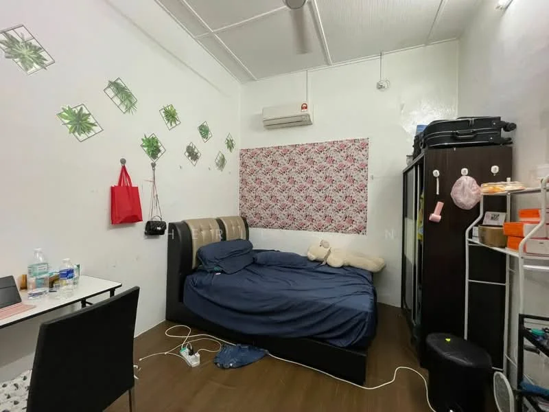 Bedroom features: queen-size bed with dark upholstered headboard, light blue bedding, wooden flooring, white painted walls, decorative wall with floral wallpaper, 1 wall-mounted split AC, study desk with chair, black wardrobe, open shelving unit, houseplants in pots, ceiling fan; style: minimalist.