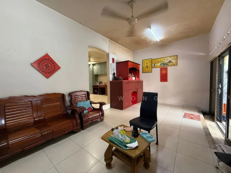 Living features: brown wooden sofa set, black dining chair, wooden coffee table, ceramic floor tiles, white painted walls, ceiling fan, wall-mounted artwork, red decorative wall hangings, sliding glass door, natural light from sliding door; style: traditional. Kitchen features: open kitchen layout, green cabinets, white countertop, stainless-steel sink, built-in oven, refrigerator, kitchen utensils visible.