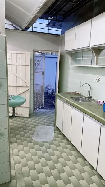Kitchen features: green countertop, single-bowl stainless-steel sink, chrome faucet, white cabinetry with flat-panel doors, green tiled backsplash, green ceramic tile flooring, window with metal grille, door leading outside, wall-mounted storage shelves, built-in cabinet, light fixture on ceiling.