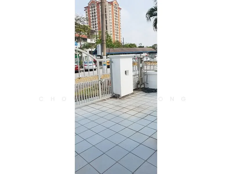 Exterior features: paved walkway, metal gate, surrounding greenery, urban context, multi-storey building in background, fenced perimeter; style: modern.