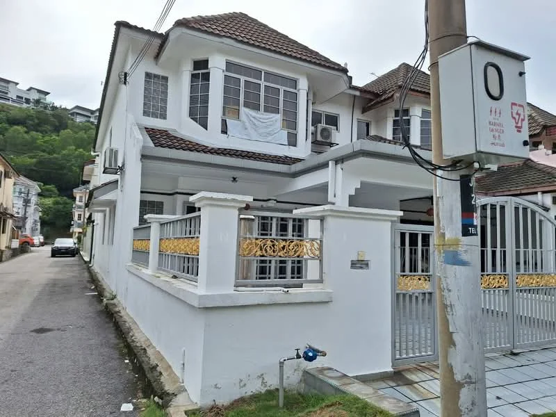 Exterior type: semi-detached house; features: white painted facade, brown tiled roof, recessed balconies, gold decorative railing, front gate with intercom, driveway with interlocking pavers, manicured lawn, surrounded by greenery; style: modern.