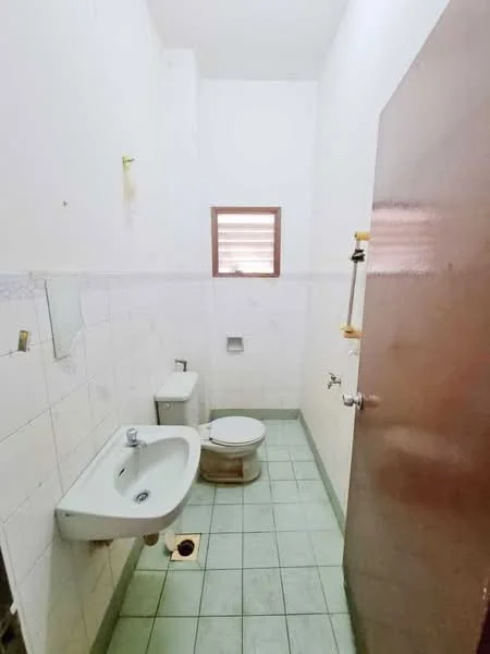 Bathroom features: white tiled walls, green ceramic tile flooring, single-sink vanity, toilet, window, shower area, mirror, towel rack.