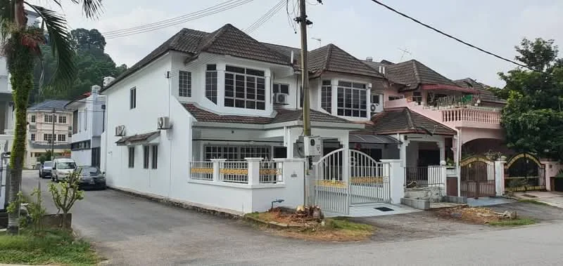 Exterior type: semi-detached house; features: white painted facade, pitched tile roof, two-storey structure, front porch with railing, multiple air conditioning units, manicured lawn, paved driveway, surrounded by greenery, gated entry, balcony on upper floor; style: modern.