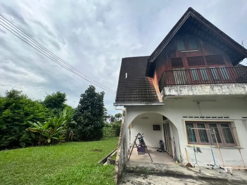 Exterior type: detached bungalow; features: sloped roof with tiles, wooden facade, balcony on upper floor, exposed brick wall, manicured lawn, surrounded by greenery, driveway, garden area; style: traditional.