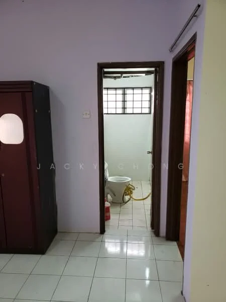 Room features: white painted walls, glossy white tile flooring, wooden door, window with grid pattern, built-in wardrobe with sliding doors, visible bathroom door, toilet visible in bathroom, plumbing fixtures in bathroom.